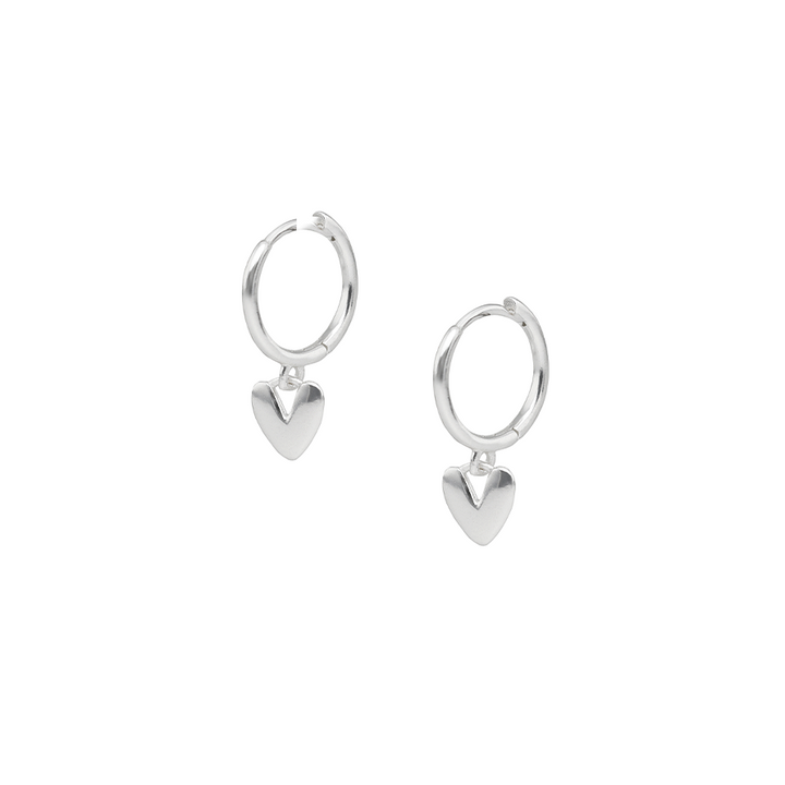 Silver heart-shaped huggie earrings on a white background